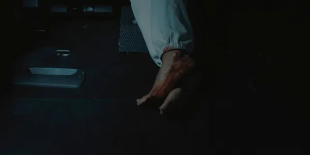 Zoe Saldaña resting a bare foot in a dramatic screen scene.