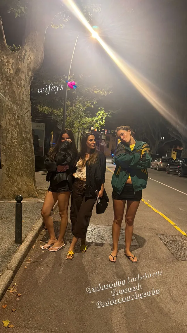Adèle Exarchopoulos standing with friends outdoors at night.