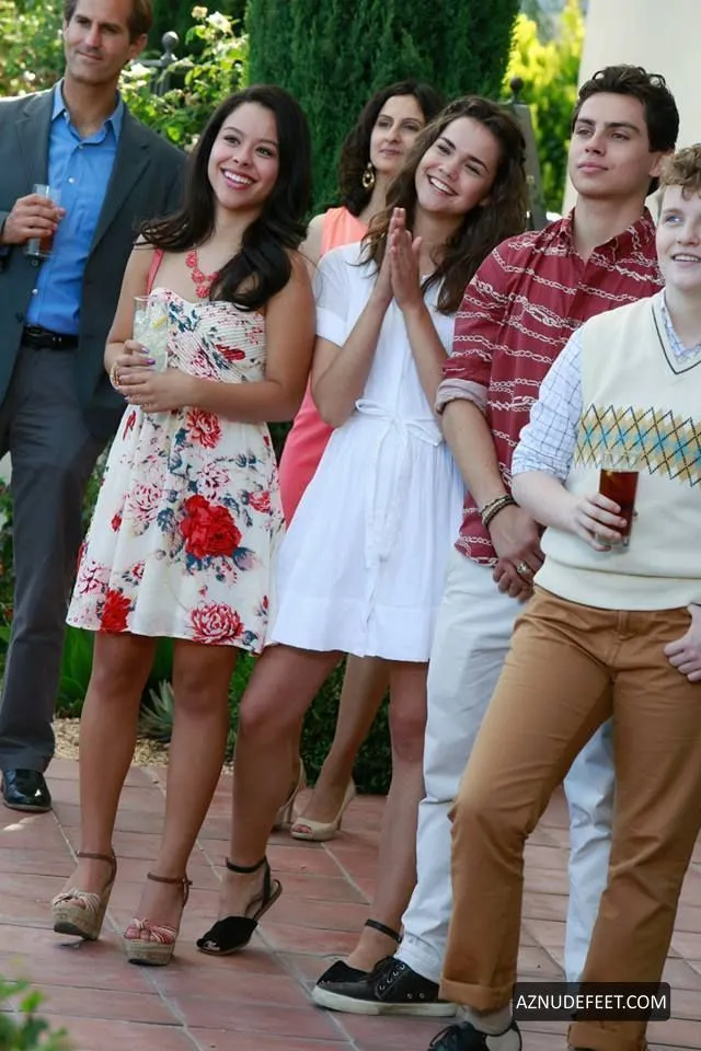 Cierra Ramirez in a floral dress and pale heeled sandals with friends at an outdoor gathering.