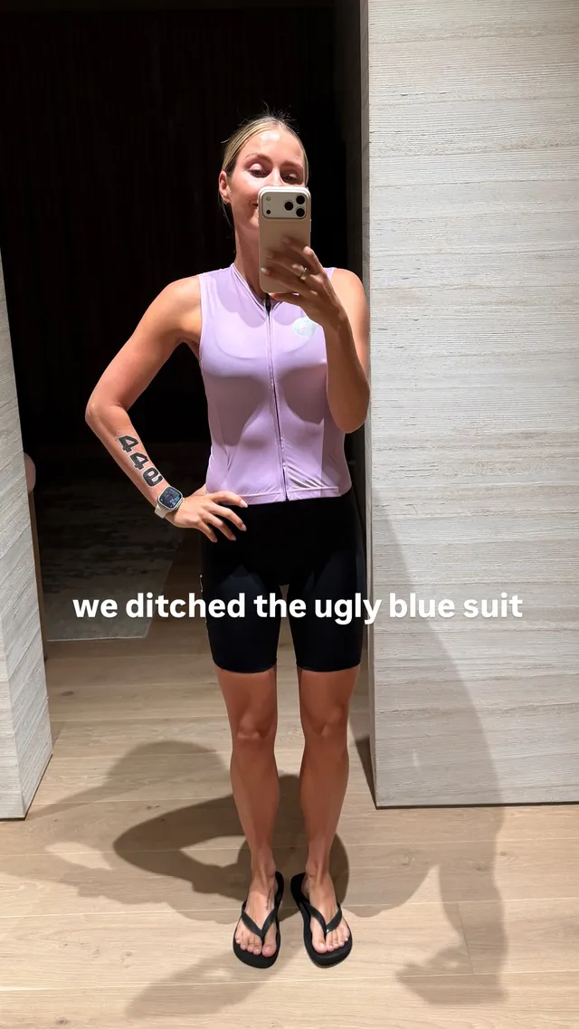 Claire Holt taking a mirror portrait in a purple top and flip-flops.