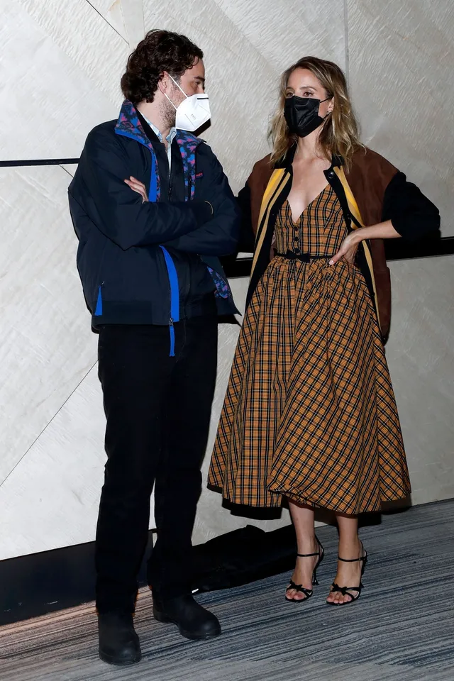 Dianna Agron standing with a companion in a checked dress.
