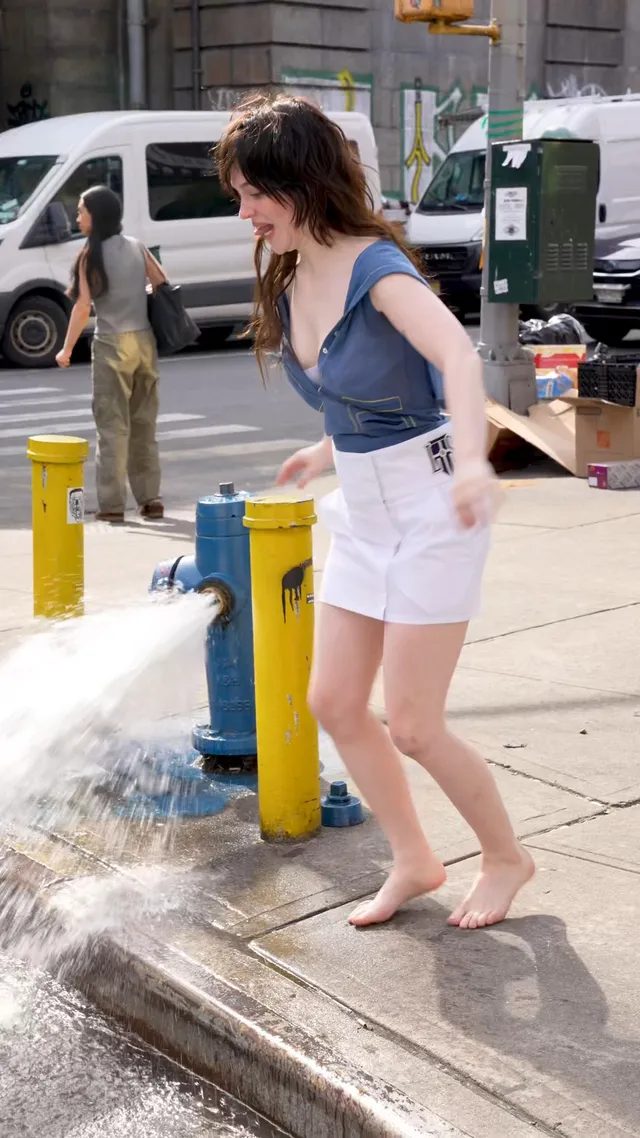 Sophie Thatcher standing barefoot beside water on a rooftop.