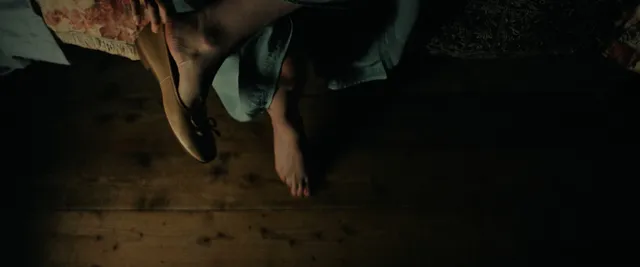 Daisy Ridley sitting near an indoor pool in a screen scene.