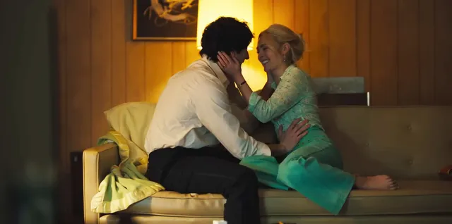 AnnaSophia Robb sitting on a bed with a companion during a screen scene.