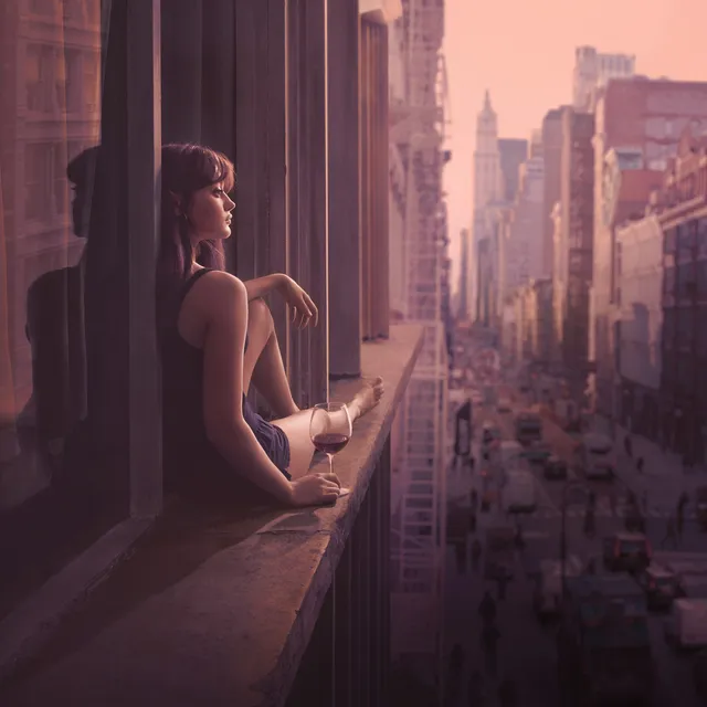 Ella Purnell sitting on a window ledge overlooking a city.