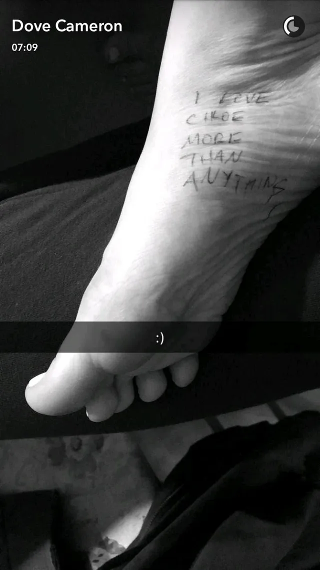 Dove Cameron showing a bare sole with handwritten lettering.