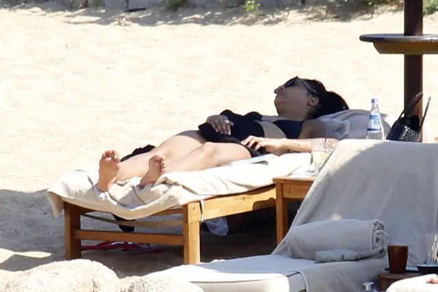Tessa Thompson relaxing on a beach lounger in sunlight.