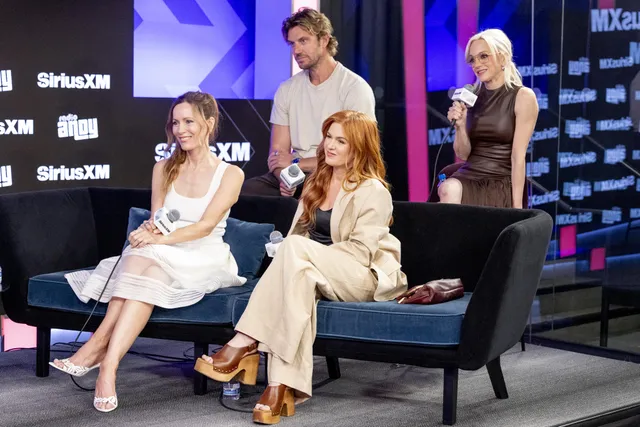 Isla Fisher sitting with fellow guests during a radio interview.