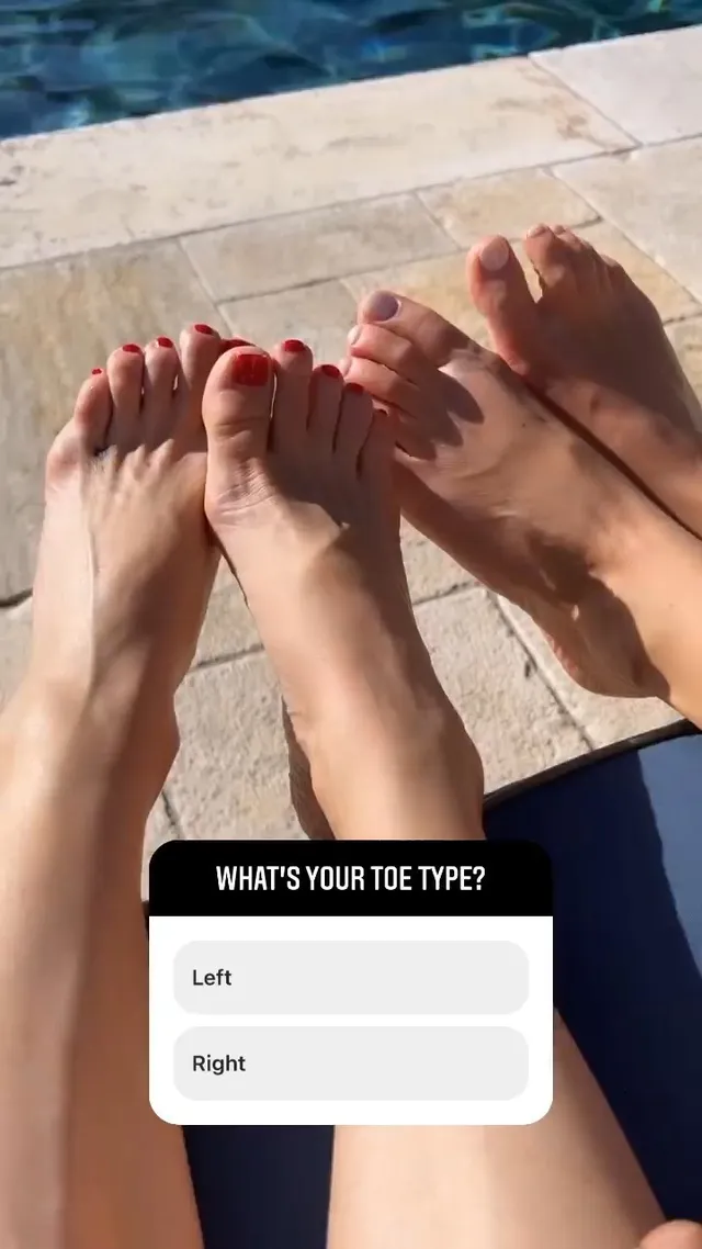 Kate Hudson resting bare feet beside another person outdoors.