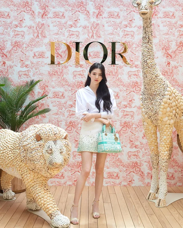 Han So-hee posing in a white jacket and pale heels.