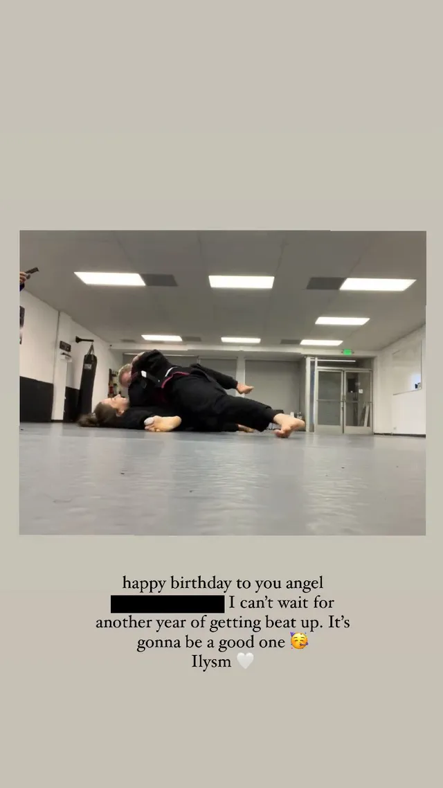 Chloë Grace Moretz stretching on the floor beside a studio mirror.
