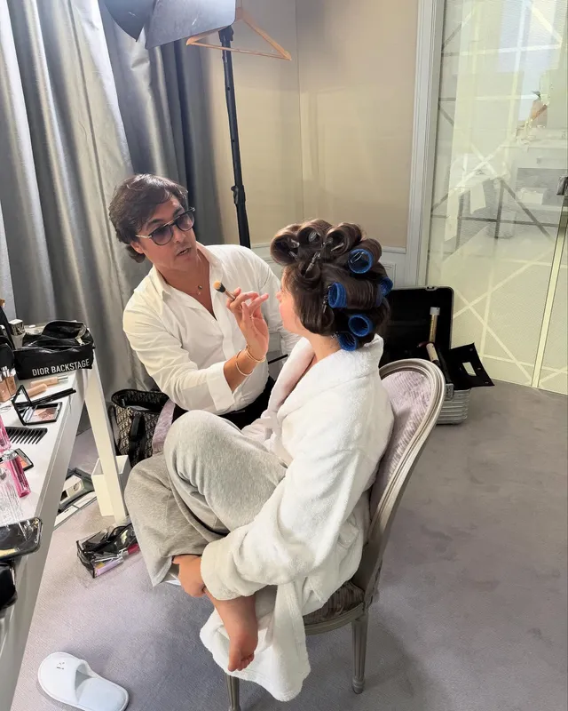 Nicole Wallace sitting barefoot in a dressing room while having her hair styled.