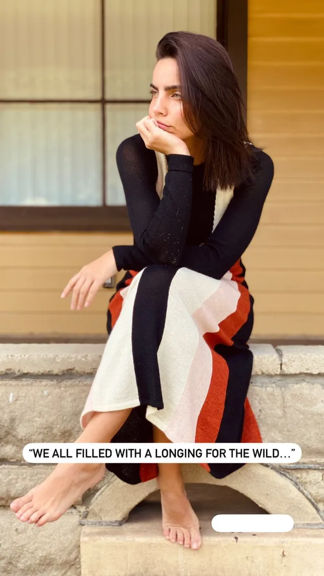 María Gabriela de Faría sitting barefoot in patterned trousers.