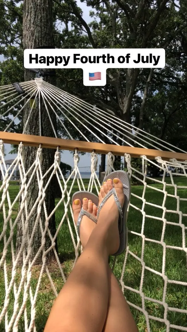 Brec Bassinger shown wearing flat sandals while resting in a hammock.