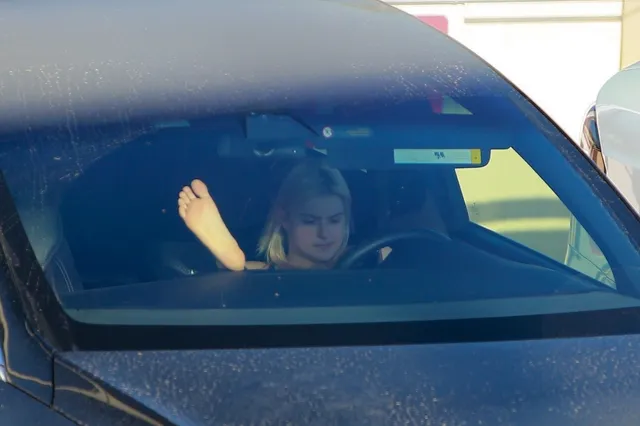 Ariel Winter a view through a car windscreen with bare feet raised.