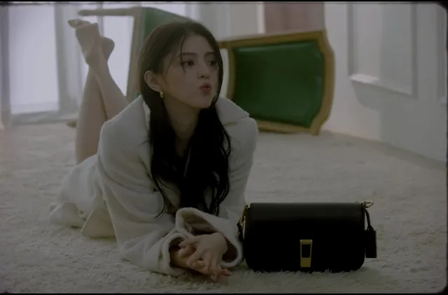 Han So-hee lying on the floor beside a handbag.