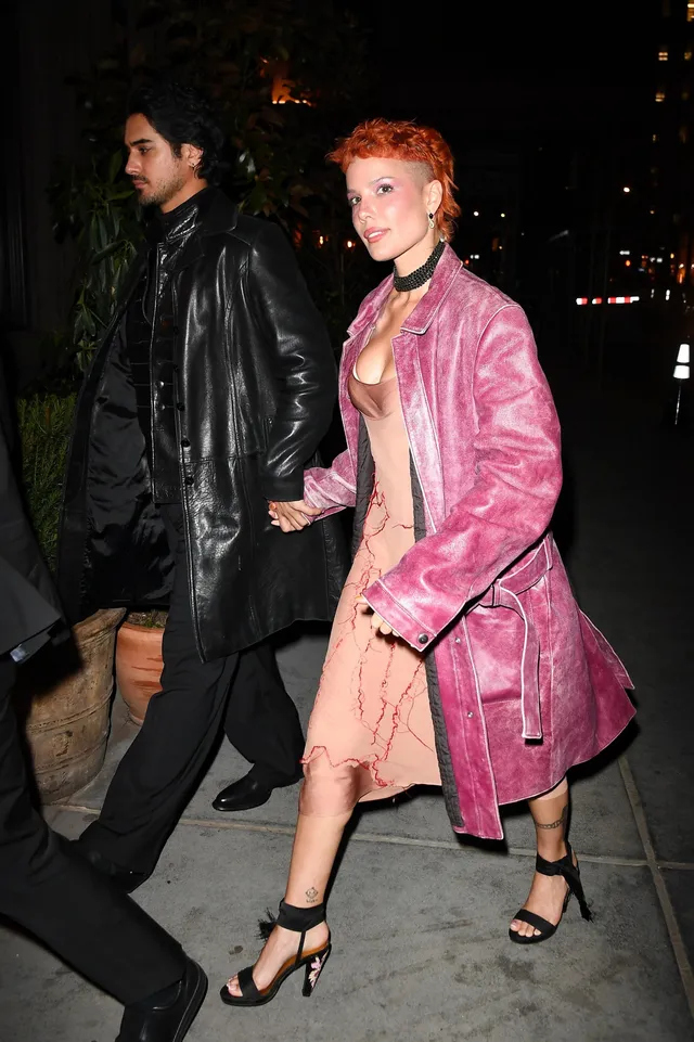 Halsey a pink coat and black heels at night.