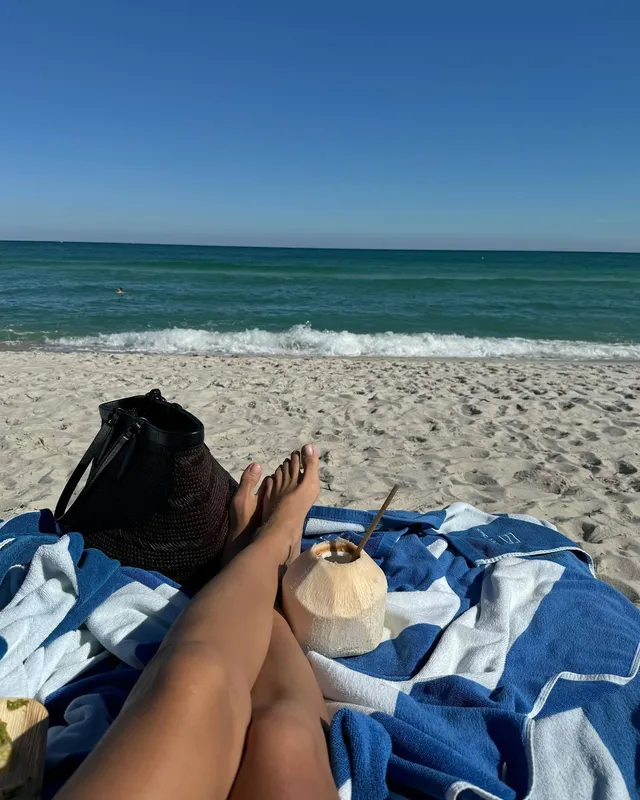 Irina Shayk bare feet resting on a beach towel.