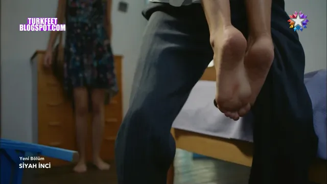Hande Erçel being carried with bare feet raised in a screen capture.