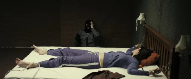 Gemma Arterton lying on a bed in a purple outfit in a screen scene.