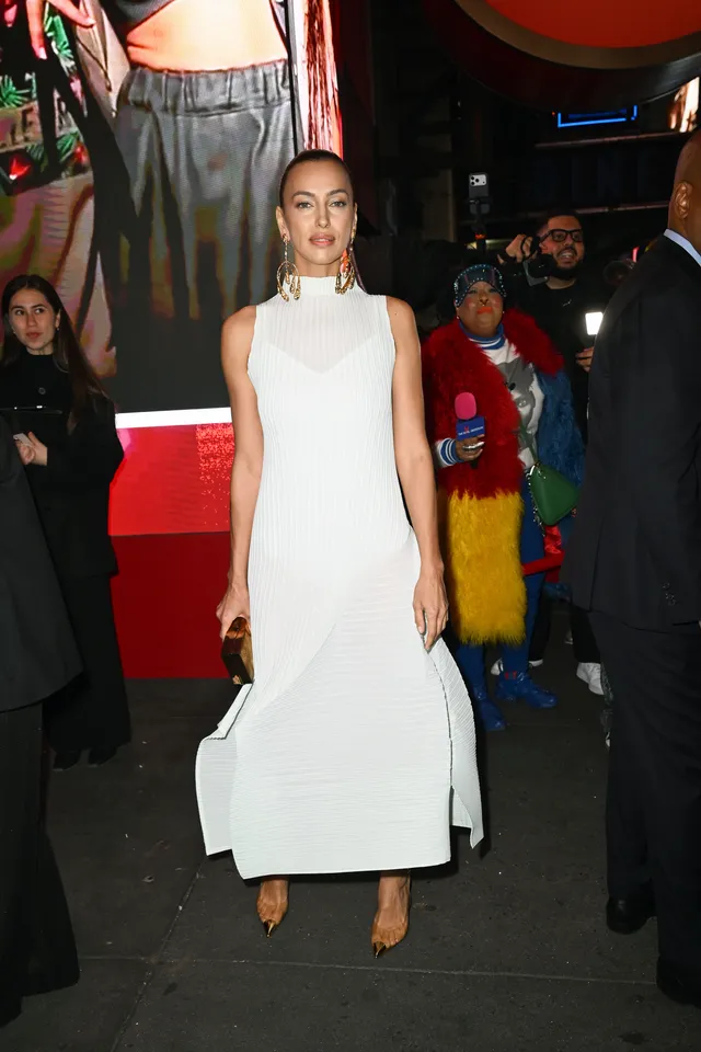 Irina Shayk a white dress and heels at an evening event.
