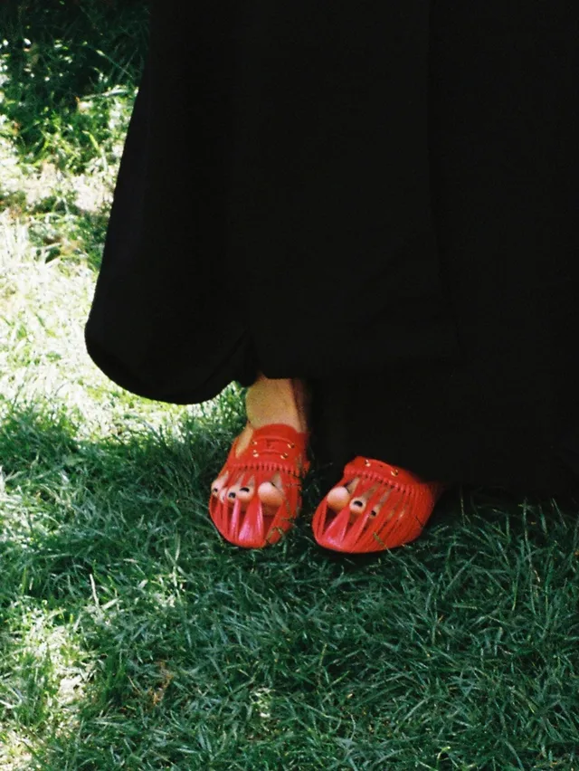 Bae Suzy wearing red flat sandals outdoors.