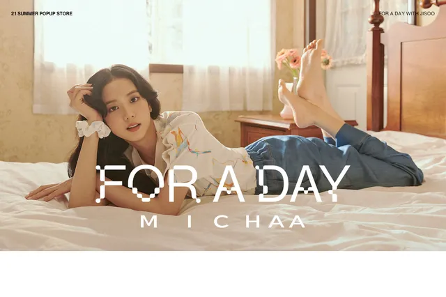 Jisoo lying on a bed with her bare feet raised in jeans and a pale top.