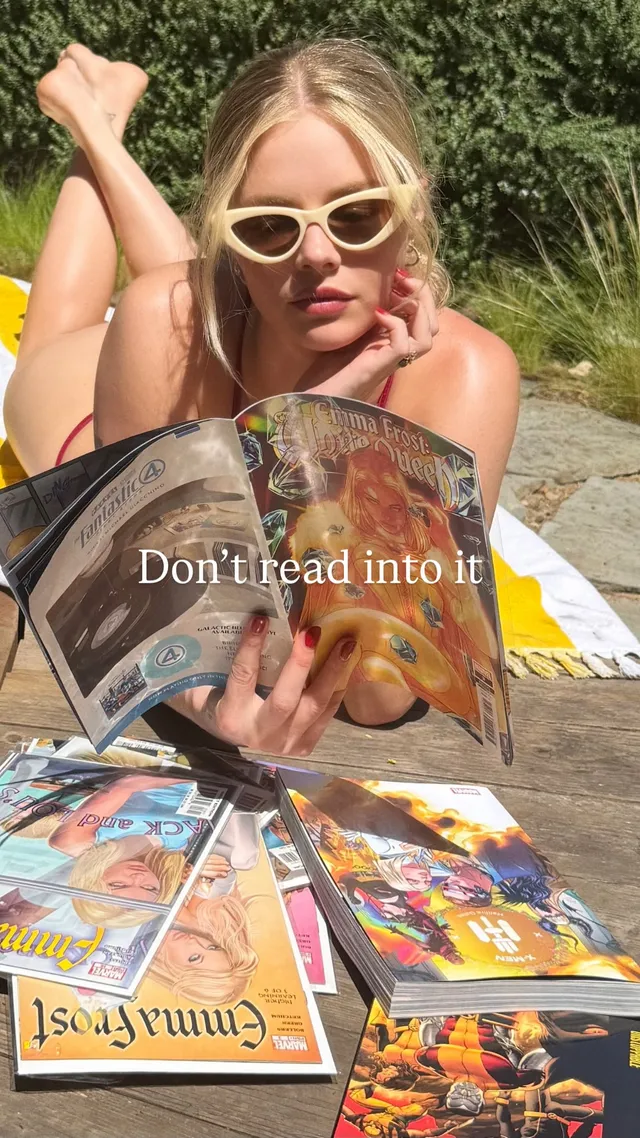 Samara Weaving reading outdoors with her bare feet raised behind her.