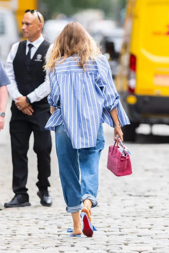 Blake Lively walking outdoors in jeans and blue heels.
