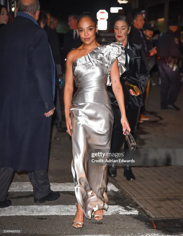 Tessa Thompson walking outside in a metallic silver gown.