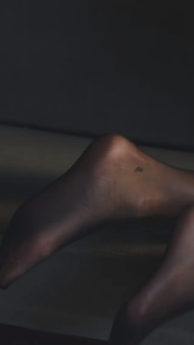 Kendall Jenner showing a bare heel in a dimly lit portrait.