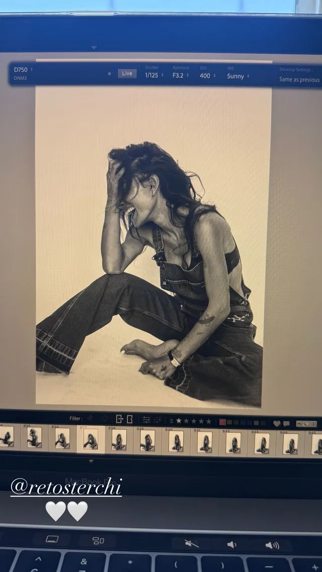 Sarah Shahi sitting for a black-and-white portrait in a dark outfit.