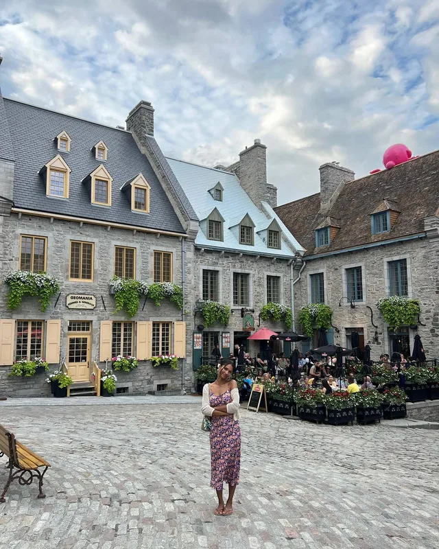 Greta Onieogou standing in a cobbled square in a floral skirt and flats.