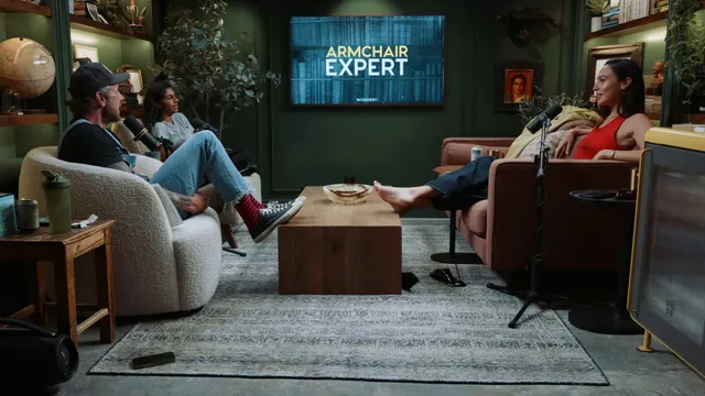 Gal Gadot sitting barefoot with a group during a conversation.