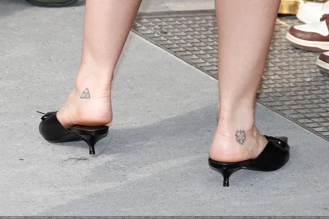 Katy Perry wearing black mule heels viewed from behind.