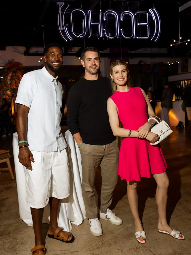 Eugenie Bouchard posing beside companions in white flat sandals and a pink dress.