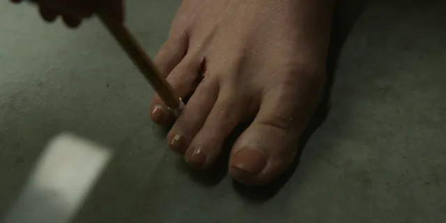 Elizabeth Olsen standing barefoot on an indoor floor.