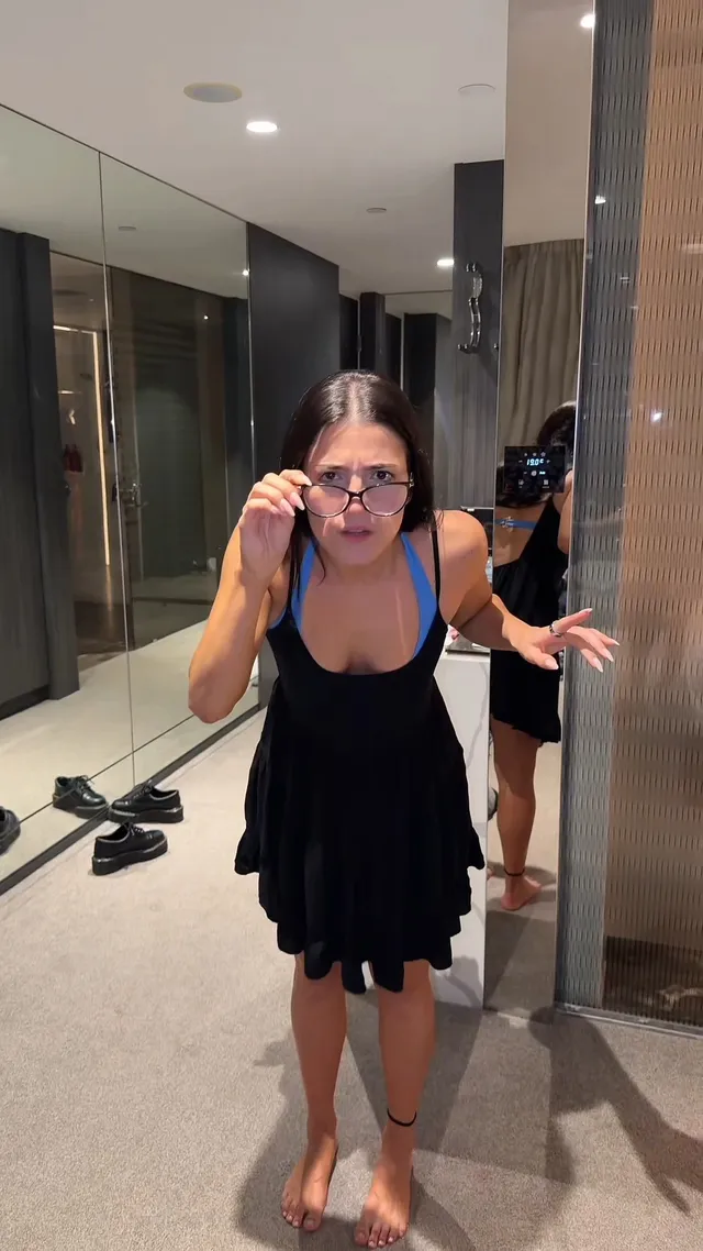 Charli D’Amelio standing barefoot in a dressing room.
