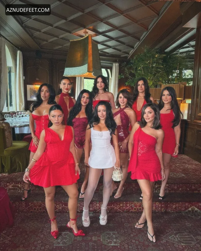 Cierra Ramirez in a short white dress posing with a group at a celebration.