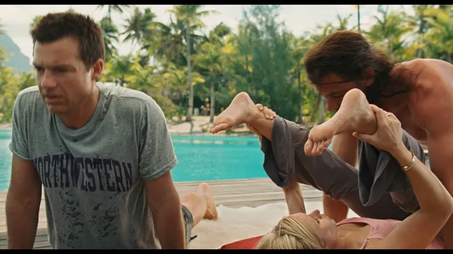 Kristen Bell with bare feet raised beside two people at a pool in a screen image.