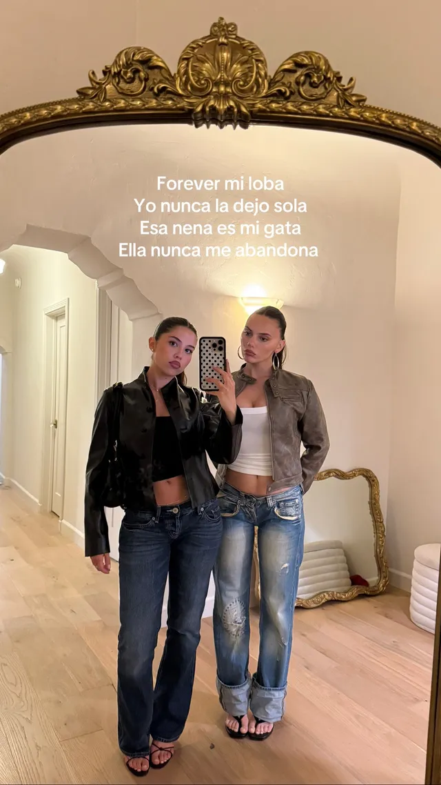 Dafne Keen taking a mirror selfie with a friend in jeans and heels.