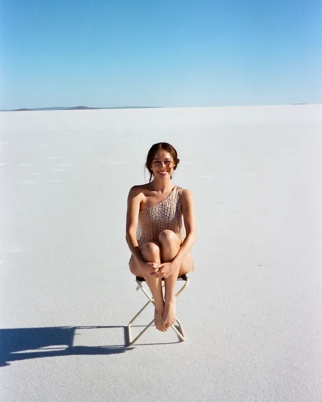 Alycia Debnam-Carey sitting with her knees drawn up during an outdoor portrait.