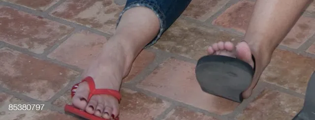 Gwen Stefani wearing red flip-flops on a tiled floor.