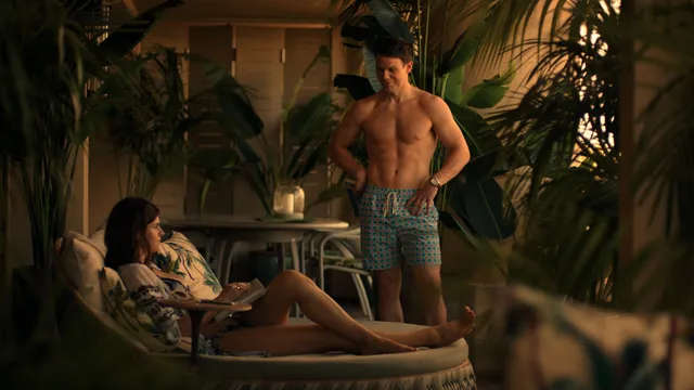 Alexandra Daddario resting barefoot on a patio sofa in a screen scene.
