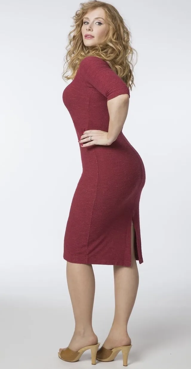 Bryce Dallas Howard posing for a studio portrait in a burgundy dress.
