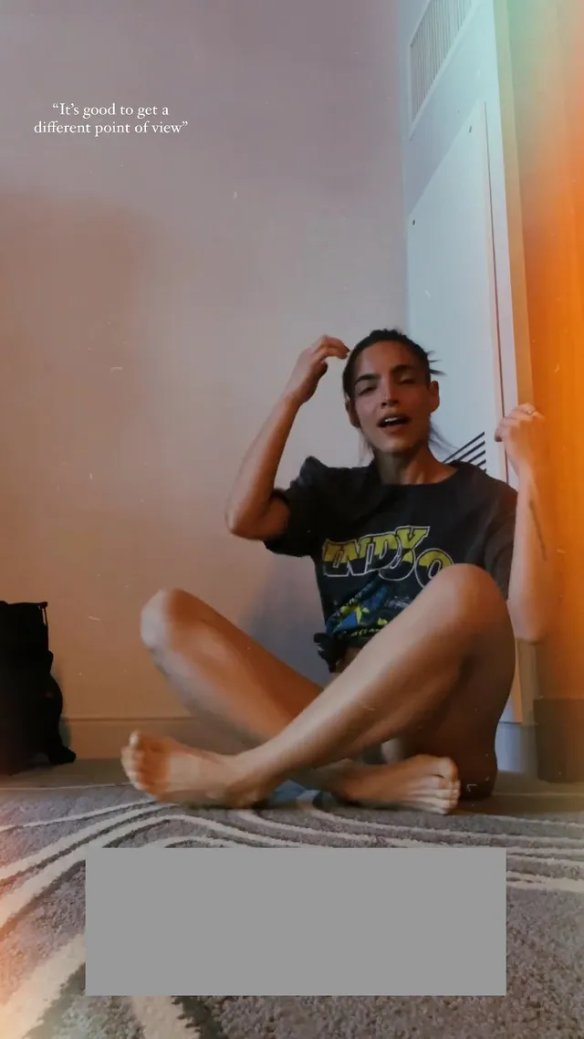 María Gabriela de Faría sitting barefoot on an exercise mat.
