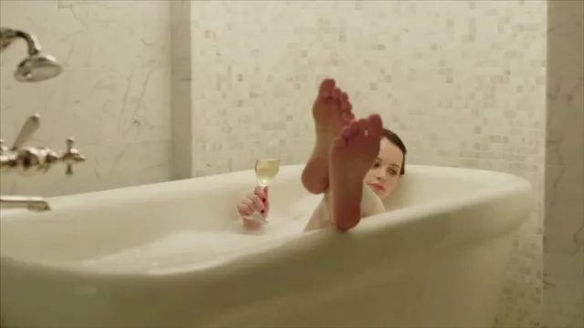 Felicity Jones relaxing in a bathtub in a screen scene.
