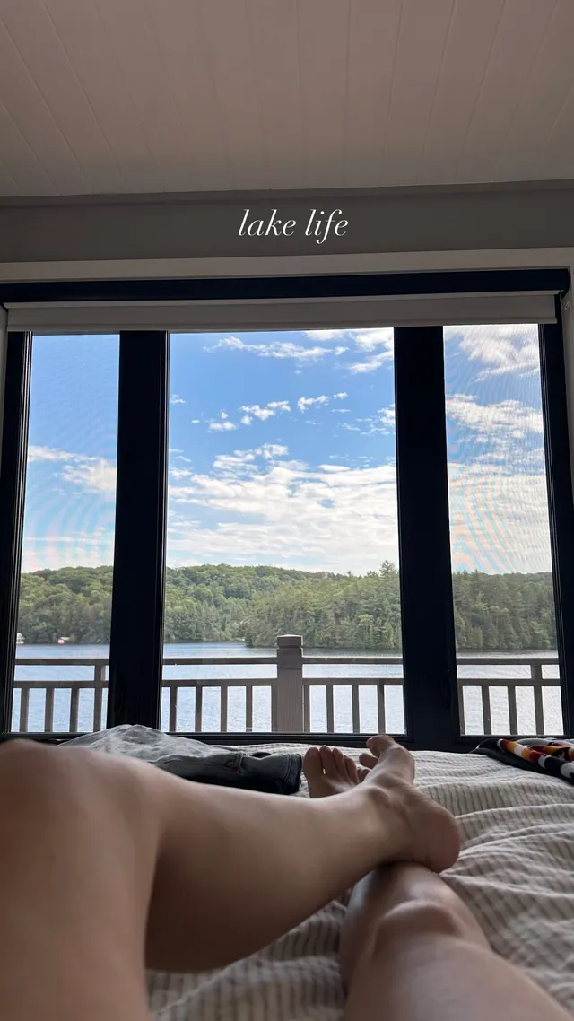 Rachel Bilson relaxing on a bed overlooking a lake.