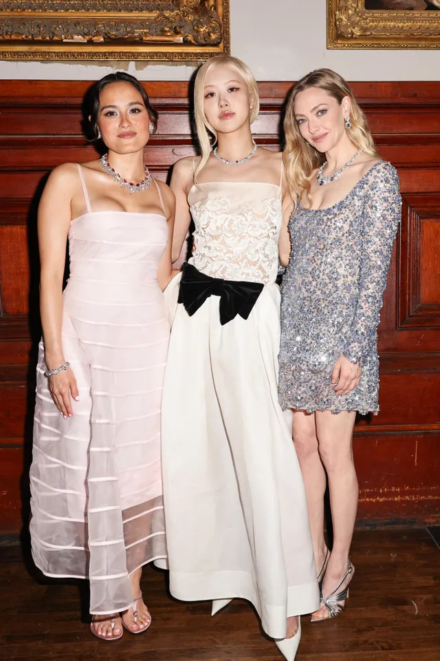 Chase Sui Wonders posing with guests in a pale gown and heels.