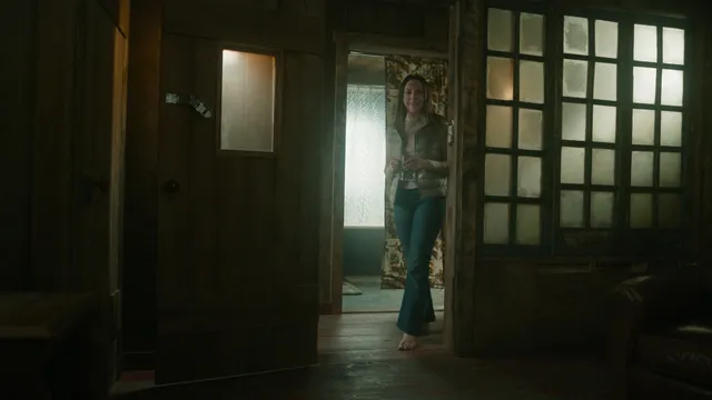 Elizabeth Gillies standing in a doorway during a screen scene.